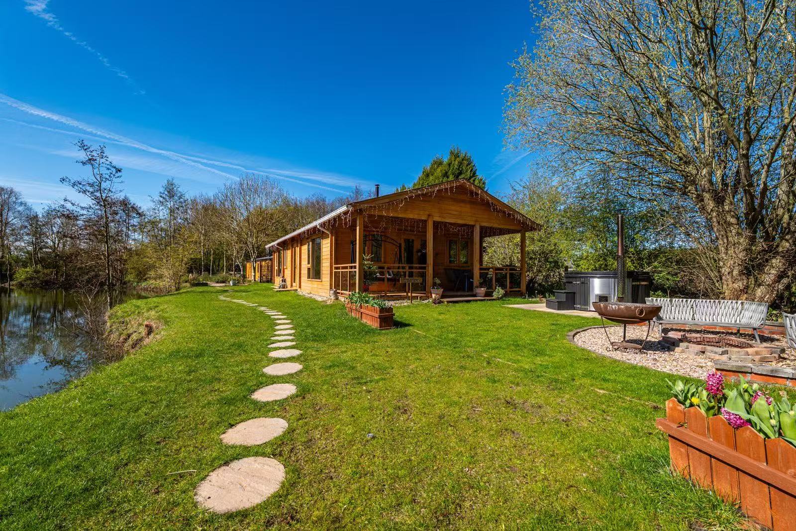 Peony Place log cabin in its lakeside setting